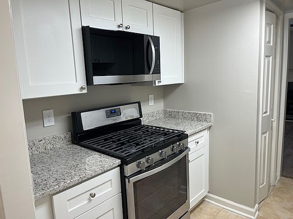 Galley kitchen w/stove/oven and microwave. New cabinets w/ granite countertops. New Microwave over stove.
