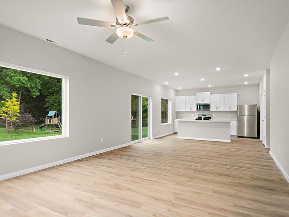 The family room is spacious with a ceiling fan and fire place.