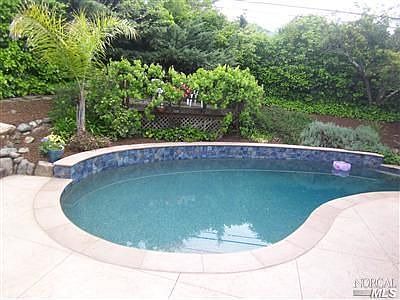 Newly remodeled Pebbletec pool with custom tile and stamped concrete decking