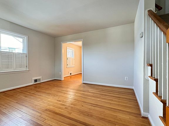 Living room with glorious hardwood floors, lots of natural lighting, plantation blinds throughout
