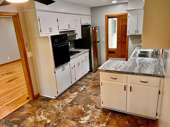 Updated kitchen with new stainless fridge and freshly painted white cabinets.