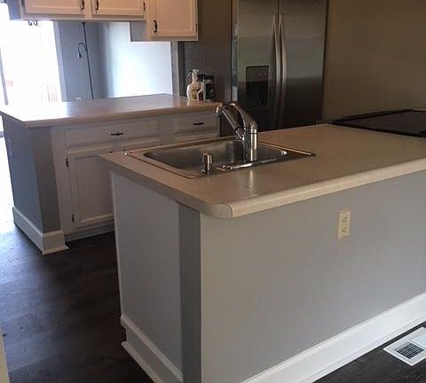 Kitchen has updated flooring and a new refrigerator