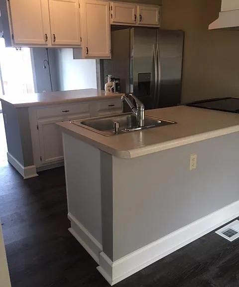 Kitchen has updated flooring and a new refrigerator