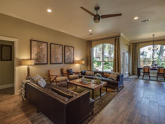 The family room has high ceilings, subtle lighting and ceiling fan looking out on to the backyard.