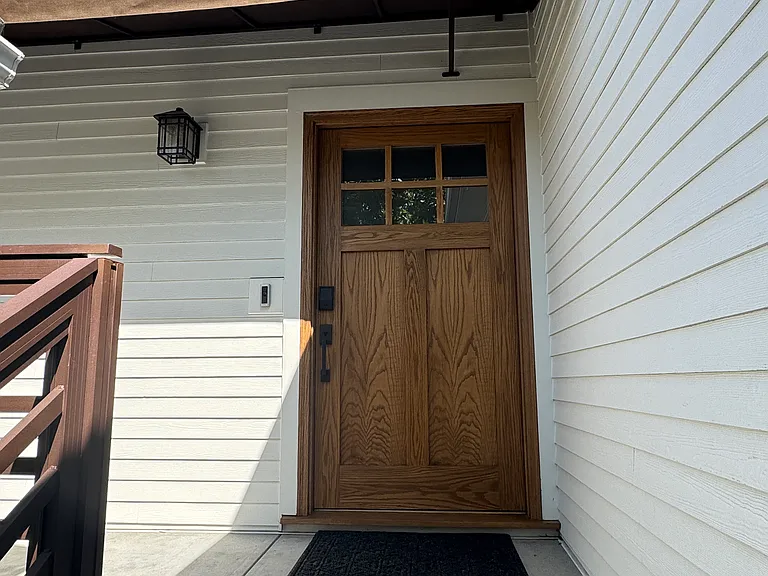Entrance with oversized oak front door and awning over it
