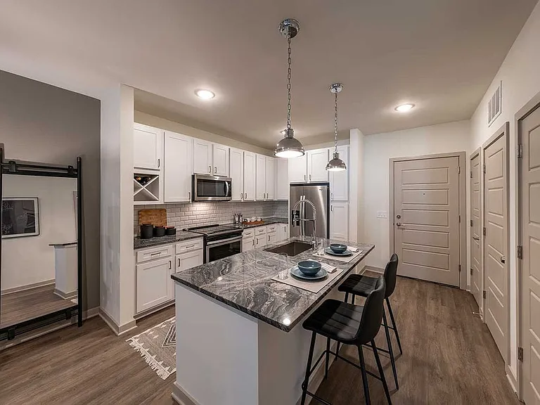 East Classic II kitchen with white cabinetry, marbled granite countertops, stainless steel appliances, tile backsplash, and hard surface plank flooring