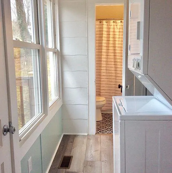 Hallway toward rear bathroom with stacked laundry unit