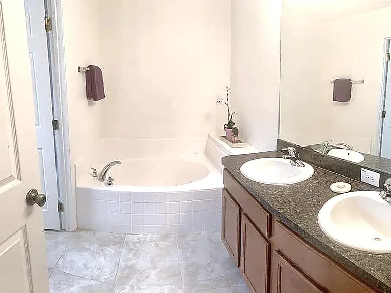 Two sink vanity and tub with separated shower and toilet