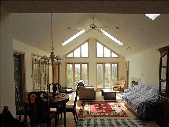 DINING AREA LOOKING INTO THE FAMILY ROOM.CATHEDRAL CEILING, FIREPLACE, SKYLITES, PADDLE FANAND DOOR TO THE DECK.