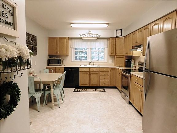 Spacious eat-in kitchen features stainless appliances, updated faucet and flooring.