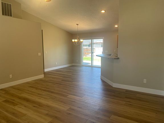 Vaulted great room looking at DR and kitchen bar on right