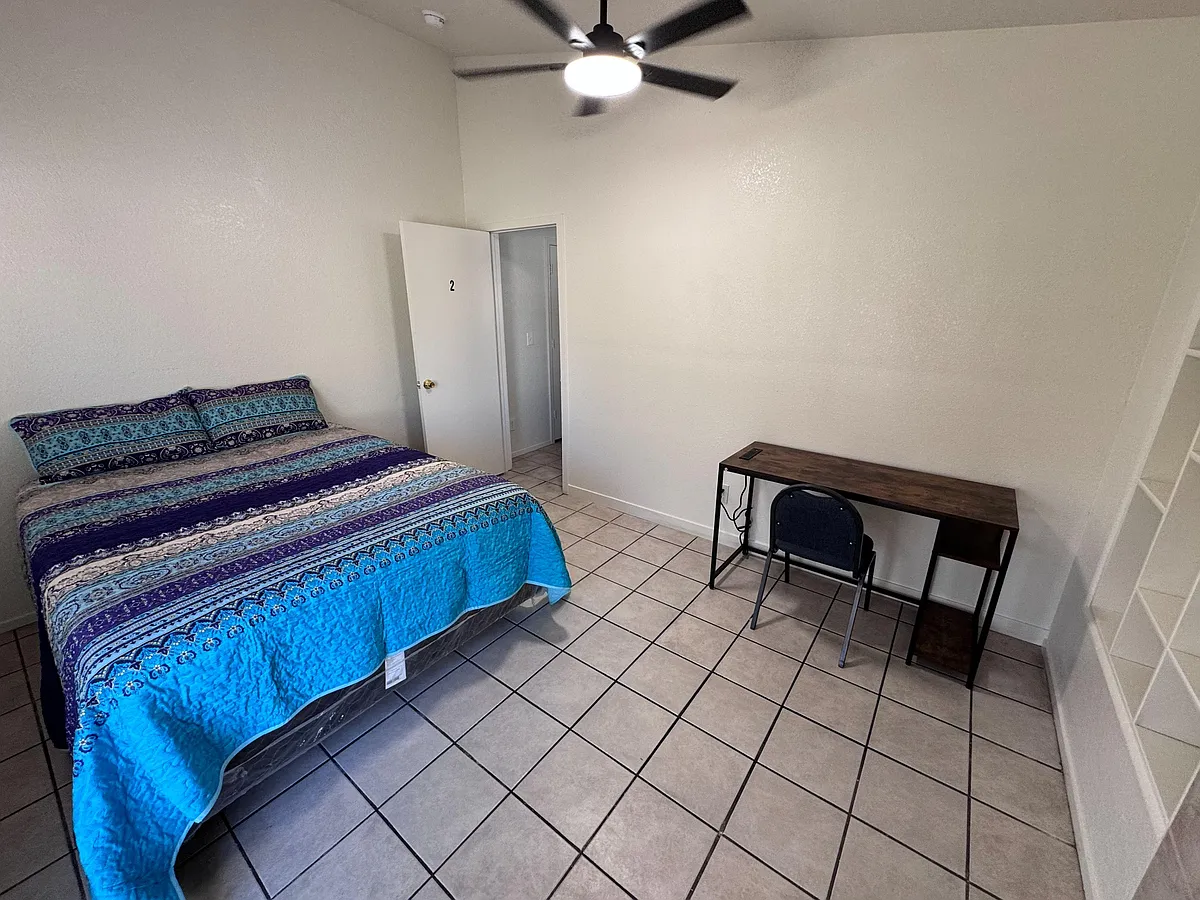Private bedroom with tile flooring, ceiling fan, and a dedicated desk/work area for studying or remote work. - Fall Meadows Ave