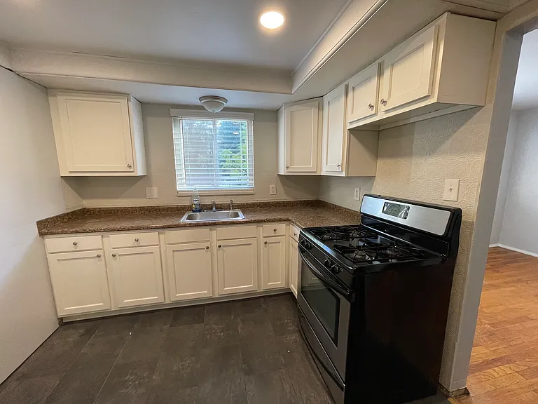 kitchen view, with dining room opening to the right - gas range with oven included, lower and upper cabinet storage