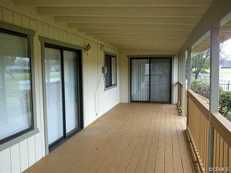 Covered rear deck with sliders leading to living room and bo