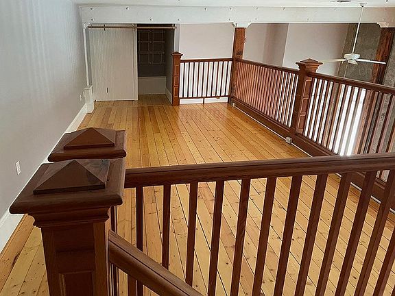 Loft style bedroom with closet space and large hanging fans for circulation.