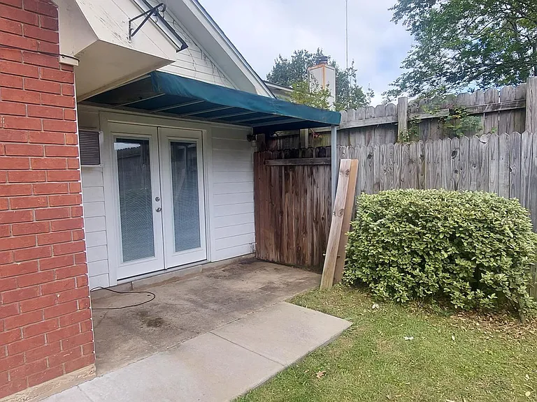 French doors open onto a shaded back patio with canopy cover.
