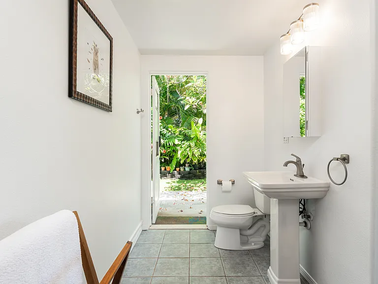 Ensuite bathroom with direct access to the private outdoor shower area and lush tropical landscaping, creating a true indoor-outdoor island living experience.