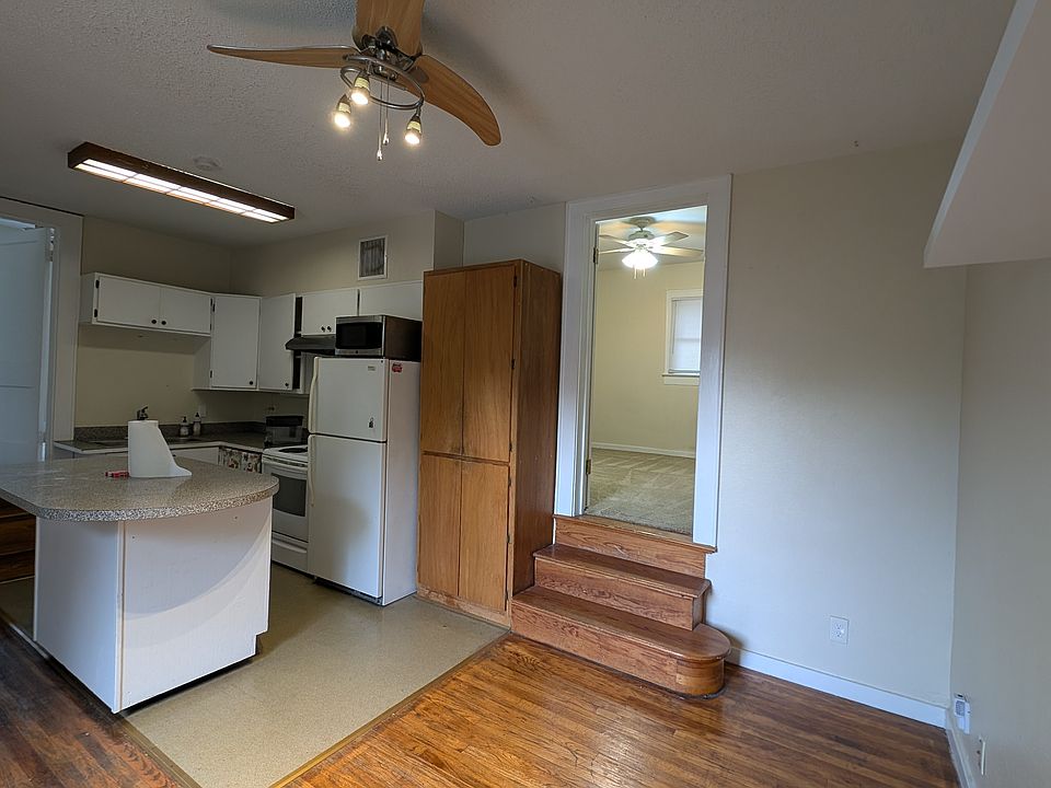 Photo of the kitchen space with one set of steps up to one of the two larger rooms.