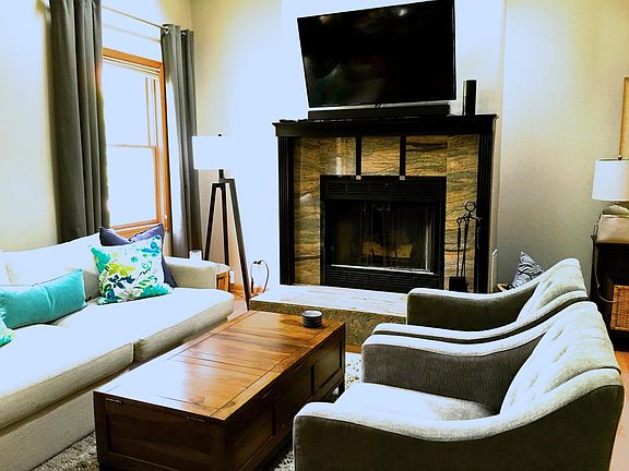 Living room with granite wood-burning fireplace.