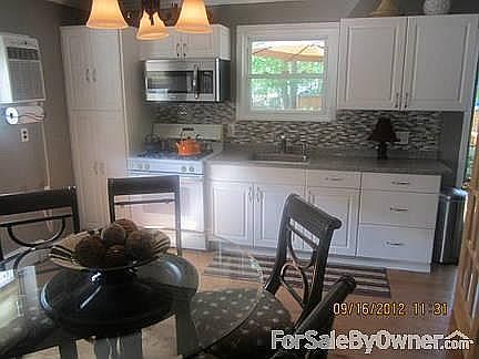 Eat-in Kitchen
						:
						13X14: white cabinetry, crown moulding.; glasstiled backsplash. wood floors