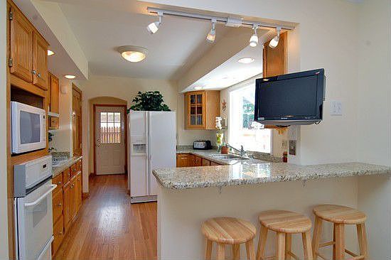 Kitchen features granite, refinished cabinets and bayed window 