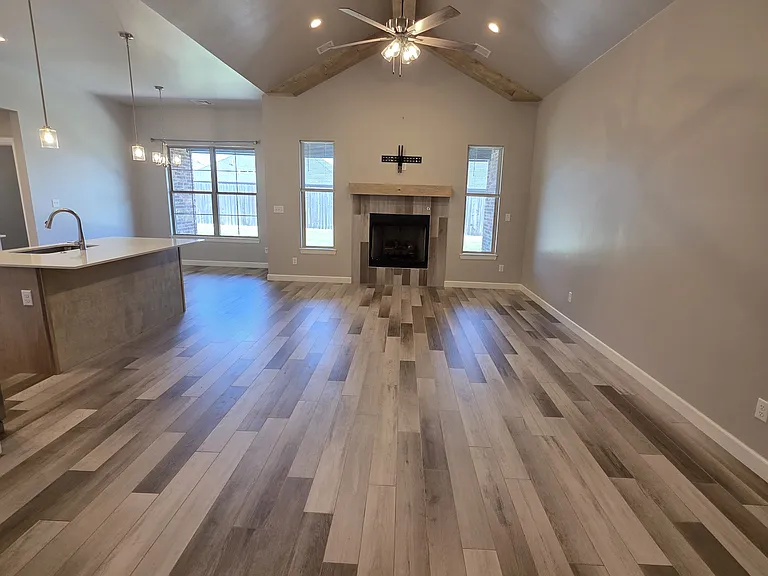 Center stage of the great room highlights the tall windows surrounding the gas fireplace and separate dining area
