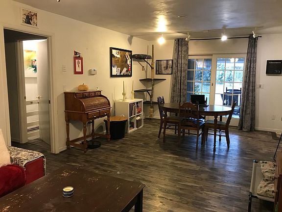 Living room/dining room with hall to L, backyard through sliding glass doors, and kitchen to R