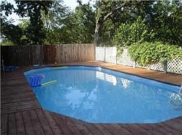 Large cedar deck with above ground pool that looks in-ground.