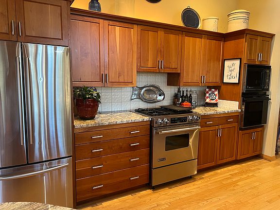 Stainless steel appliances. Jenn-Air Gas cooktop with grill accessory and oven, GE confection/micowave and 2nd oven. Additional smaller refrigerator and short freezer in the garage.