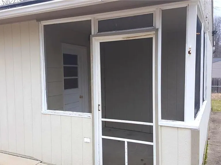 Small enclosed porch adjacent to garage