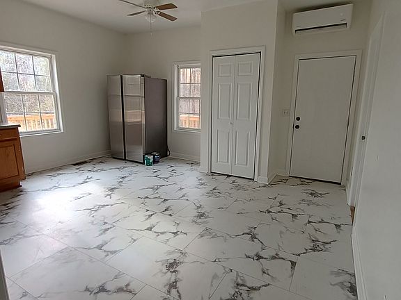 Entry door, large kitchen with Samsung appliances, and panty with shelving.