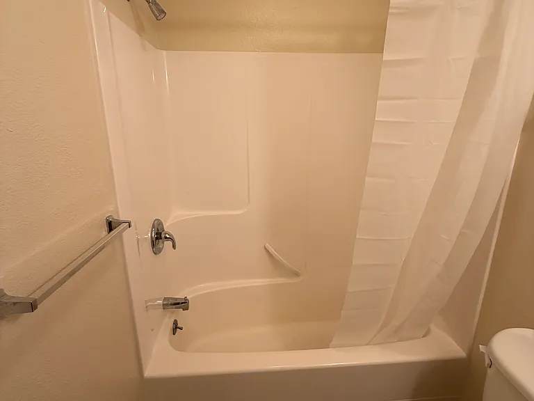 Master bathroom with curved shower curtain rod for more elbow room.