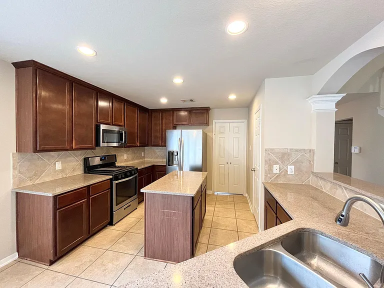 kitchen with cherry cabinets and granite countertop. Refrigerator is included