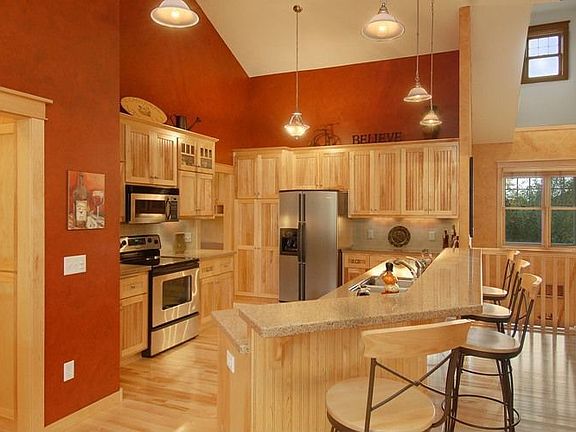 Gourmet kitchen features birch cabinets and floors 
