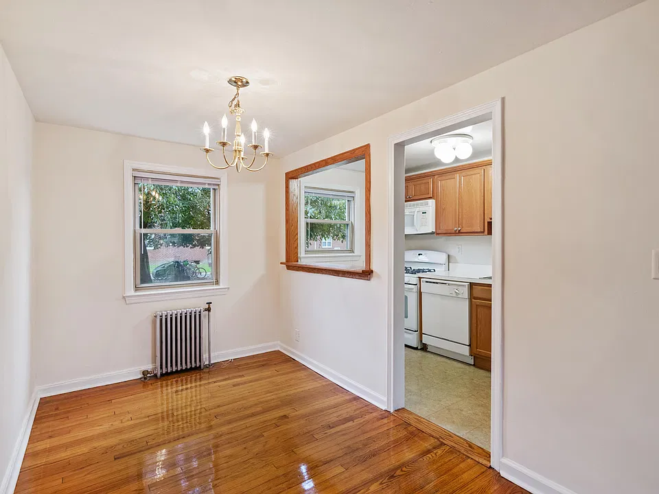 Dining room with a chandelier, a window, and a door leading to a kitchen