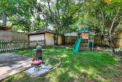 Kids play set. Side entrance to exit garage inside fenced yard. Large trees. Lots of shade.