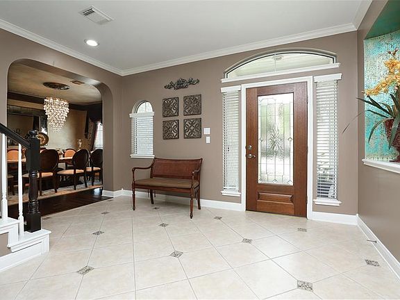 Another view of the entry highlighting the crown molding, recessed lighting and the formal dining room adjacent.