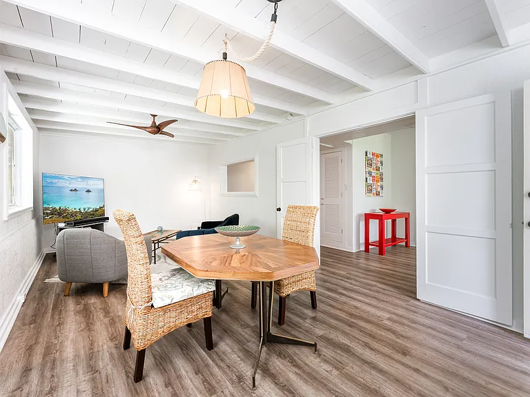 Bright entry room in the main home featuring open beam ceilings, luxury vinyl flooring, and abundant natural light.