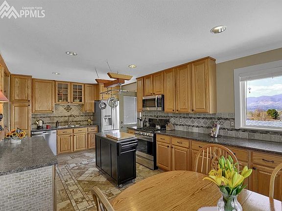 The spacious eat-in kitchen has beautiful tile flooring and stainless steel appl