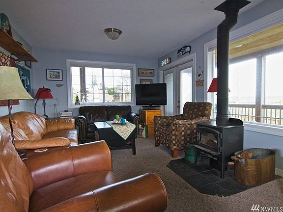 A cozy living room with a grand view of the bay and wood burning fireplace.