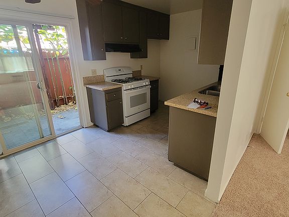 Kitchen with eating area opens to a private patio with trees.