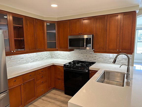 Modern, newly renovated kitchen finishes with solid surface stone counter tops and stainless steel appliances throughout.