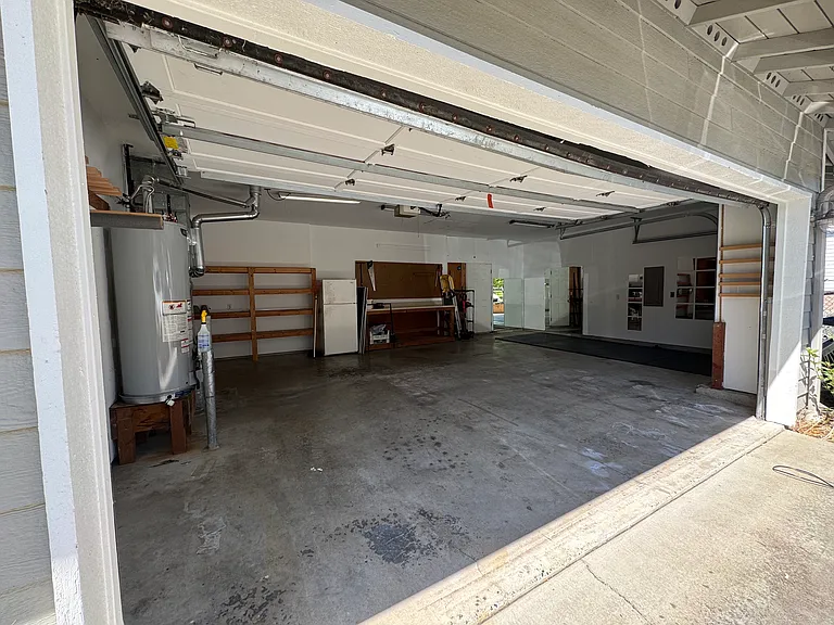XL 3-Car Garage w/ Backyard Access, Storage Shelving, Workbench, Extra Fridge, & Home Gym Area