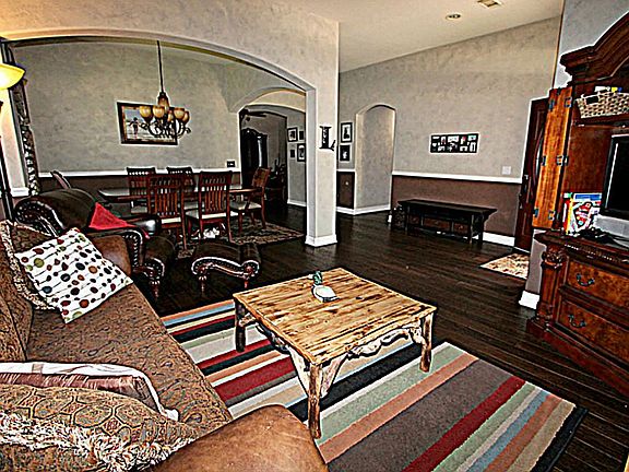 THE ELEGANT FORMAL LIVING WITH HAND SCALLOPED HARDWOOD FLOORS AND ARCHWAYS.