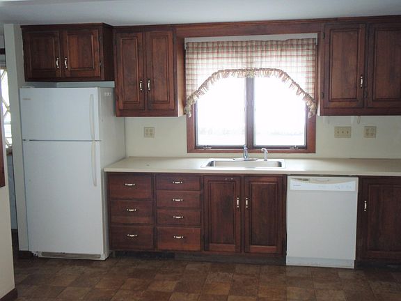 Kitchen has lovely hardwood cabinets, fridge, dishwasher and stove
