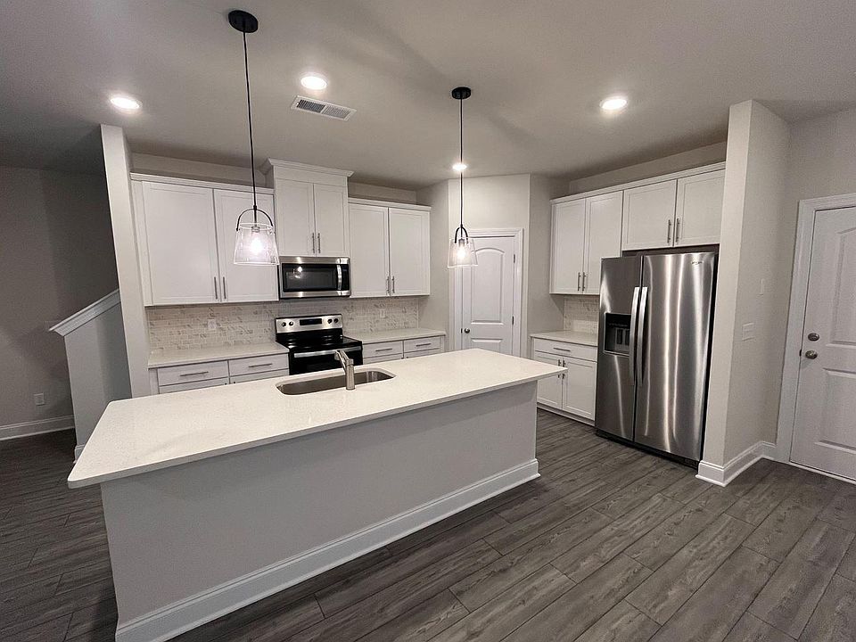 The Kitchen includes quartz countertops, stainless steel appliances and a subway tile backsplash.