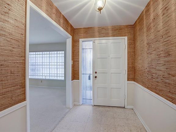 Welcome home! Lots of natural lights flows in from side light. Marble foyer and grasscloth wallpaper with chair rail define entry.
