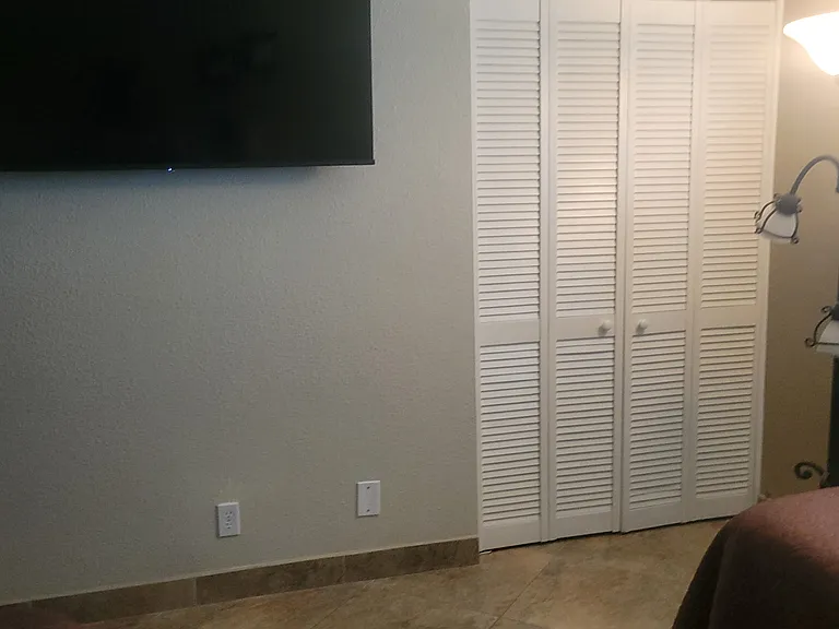 Closet door and 55-in. tv with streaming service in the Twin bedroom.