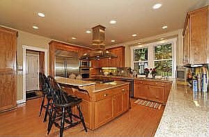 Kitchen with slab granite, stainless steel appliances & ample alder cabinets.