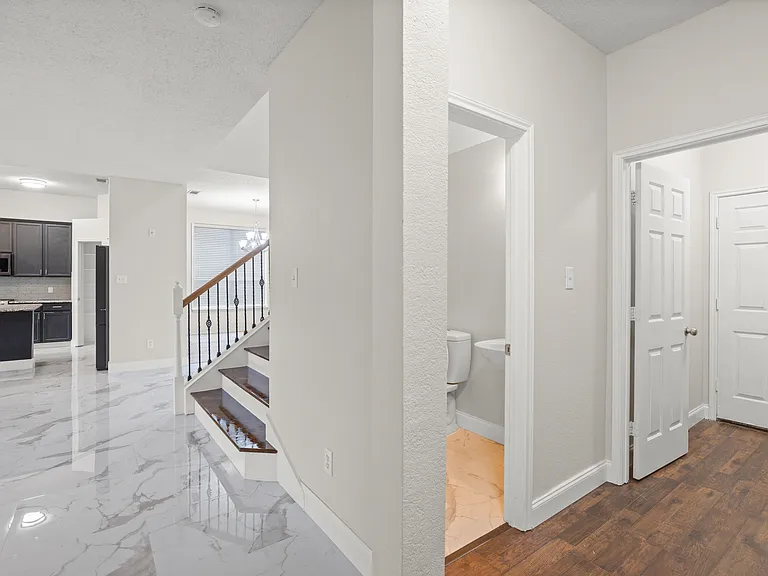 In front of the primary bedroom door you will see half bath and utility room